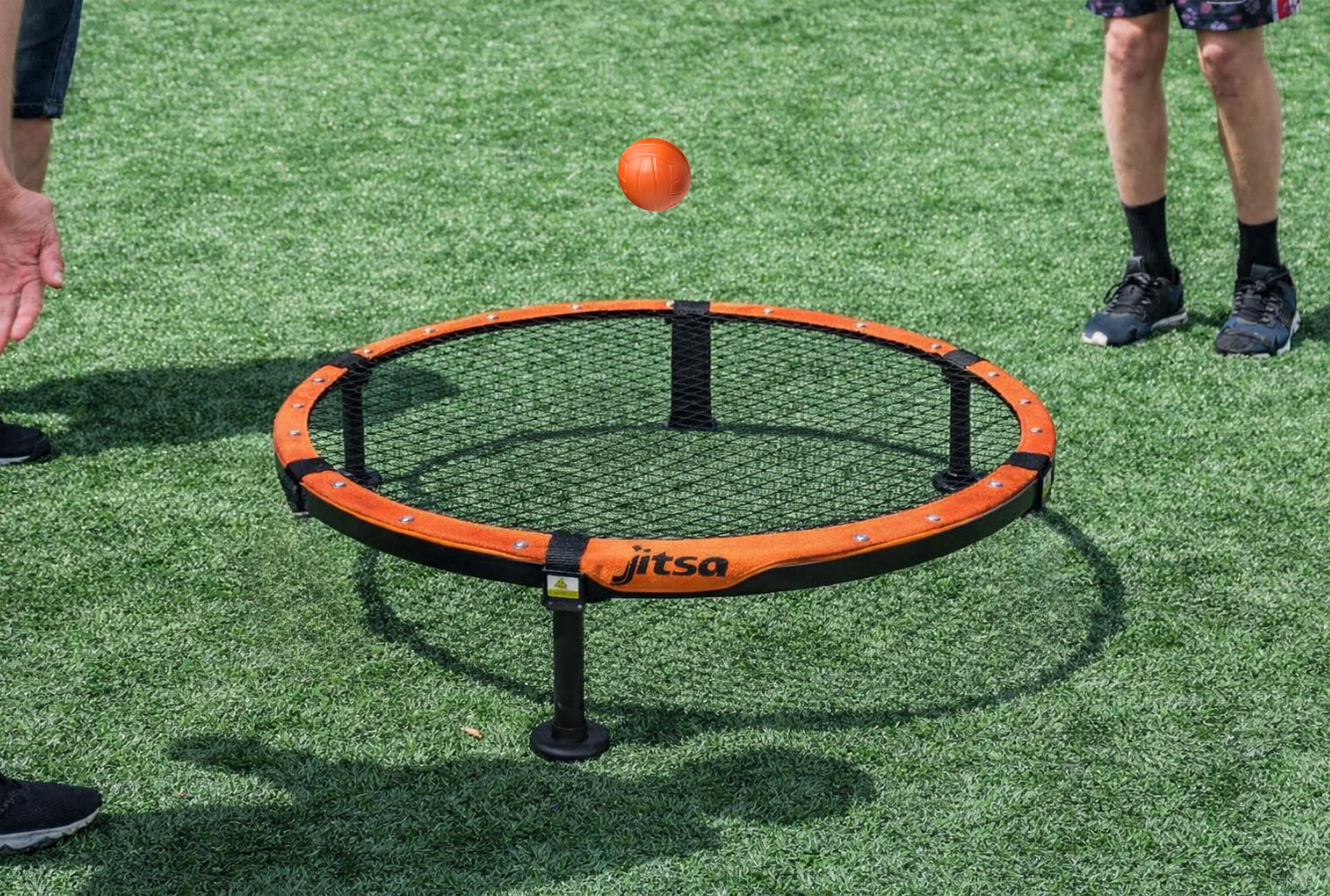 Roundnet Metalowy JITSA rozstawiony na trawie z graczami